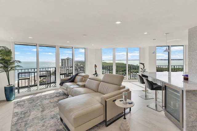 living room featuring floor to ceiling windows, a water view, and wine cooler