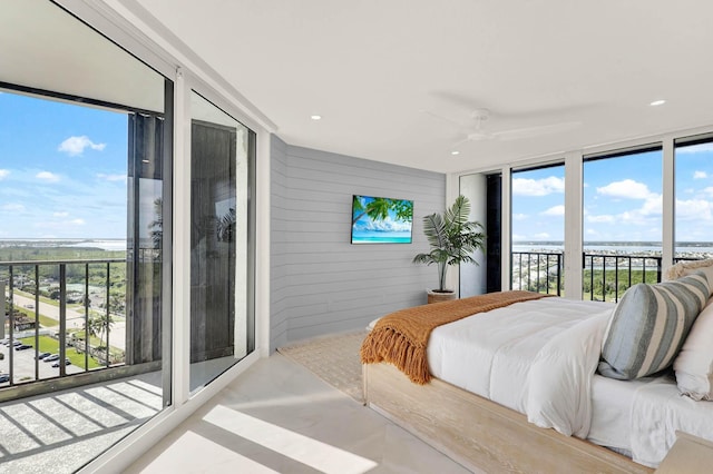 bedroom with ceiling fan, wooden walls, and access to exterior