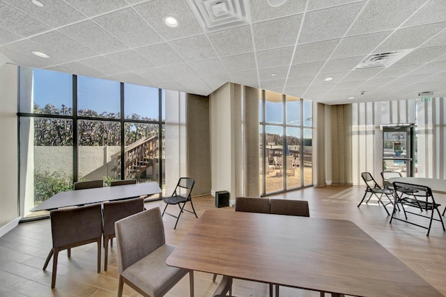 dining room with expansive windows, light hardwood / wood-style flooring, and a wealth of natural light