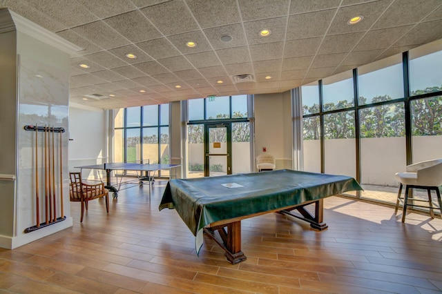 playroom with a wall of windows, pool table, light hardwood / wood-style floors, and a drop ceiling