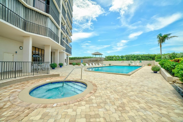 view of pool with a hot tub and a patio area