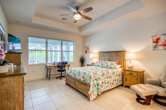 tiled bedroom featuring ceiling fan and a tray ceiling