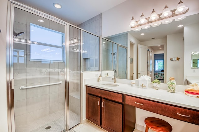 bathroom featuring tile patterned flooring, vanity, a wealth of natural light, and an enclosed shower