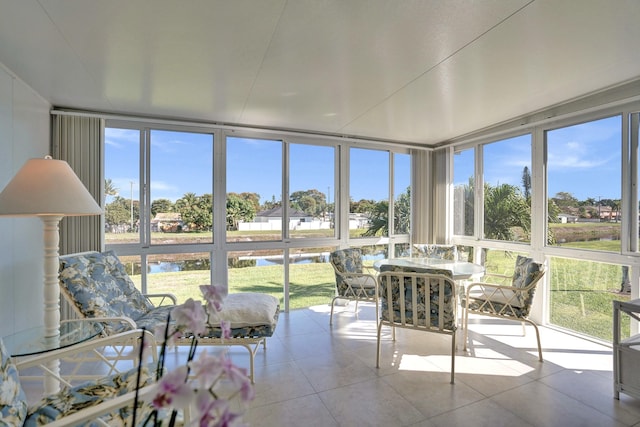 sunroom featuring a water view