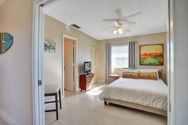 bedroom with light tile patterned floors, a textured ceiling, and ceiling fan