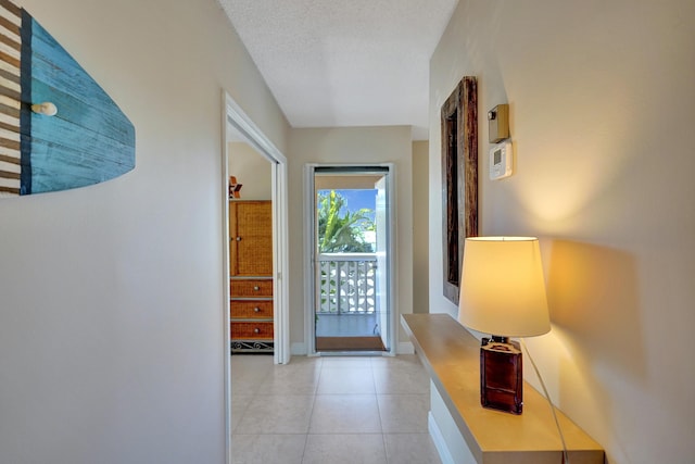 hall with light tile patterned floors and a textured ceiling