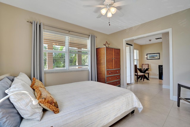 tiled bedroom featuring ceiling fan and multiple windows