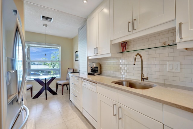 kitchen with sink, stainless steel fridge with ice dispenser, dishwasher, pendant lighting, and white cabinets