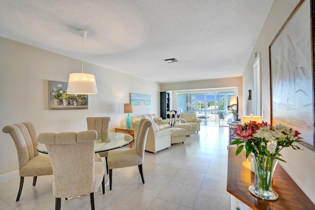 tiled dining space with a textured ceiling