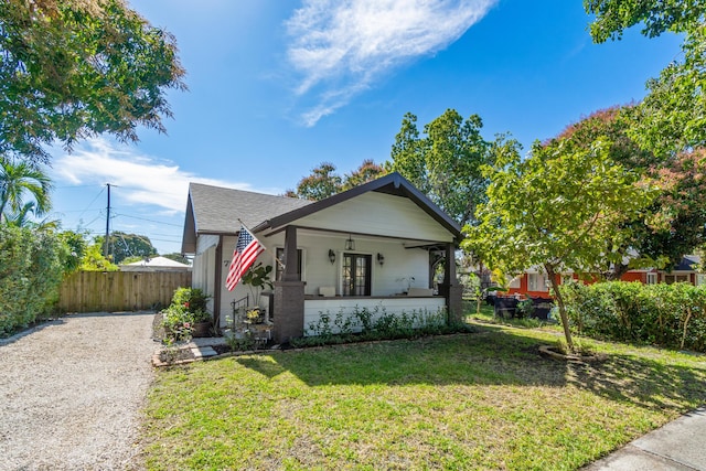 bungalow-style home with covered porch and a front lawn