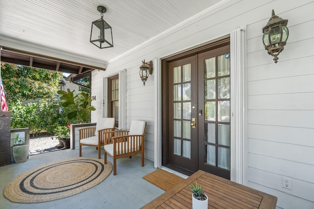 doorway to property featuring covered porch and french doors