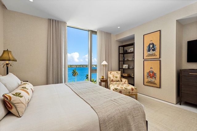 carpeted bedroom featuring a wall of windows and access to exterior