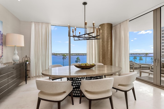 dining space with expansive windows, a chandelier, and a water view