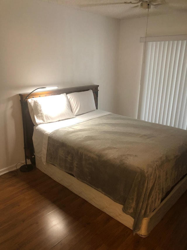 bedroom with dark hardwood / wood-style flooring