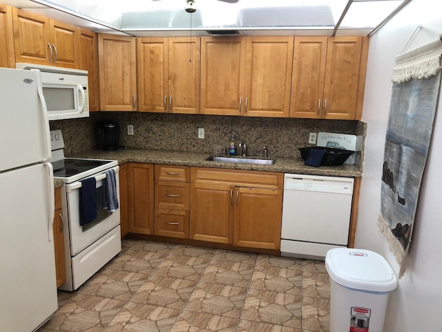 kitchen with tasteful backsplash, white appliances, sink, and dark stone countertops