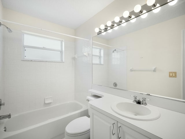 full bathroom with tiled shower / bath, vanity, and toilet