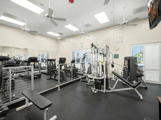 gym with a high ceiling and ceiling fan