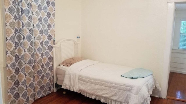 bedroom with dark hardwood / wood-style floors