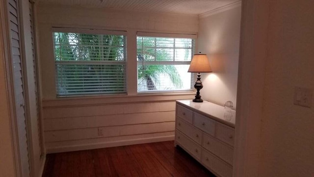 unfurnished bedroom featuring crown molding, dark wood-type flooring, and wood walls