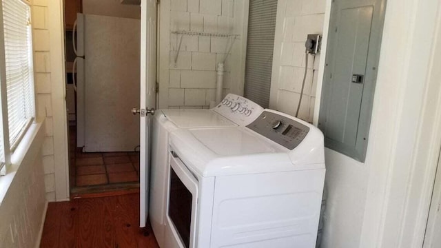 laundry room featuring washer and clothes dryer, electric panel, and dark hardwood / wood-style floors