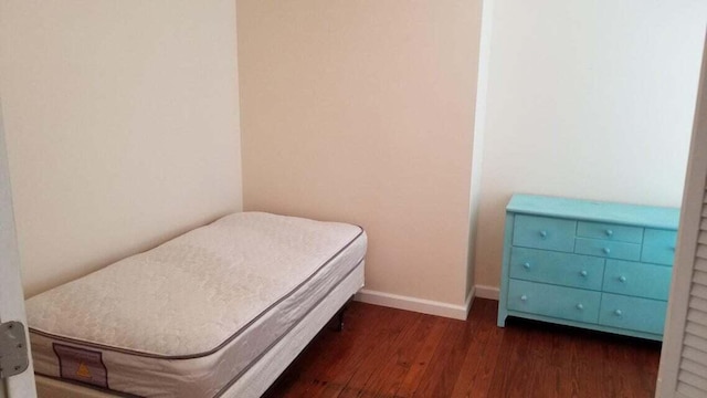 bedroom with dark hardwood / wood-style floors