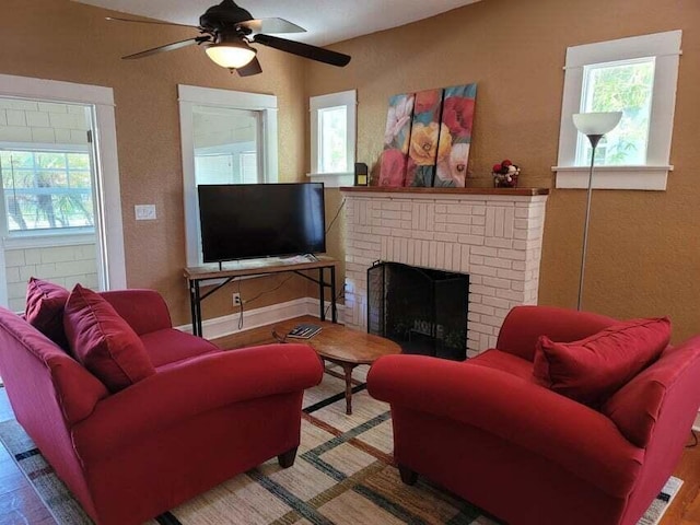 living room with a brick fireplace and ceiling fan