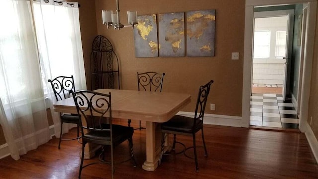 dining area with a chandelier and dark hardwood / wood-style flooring