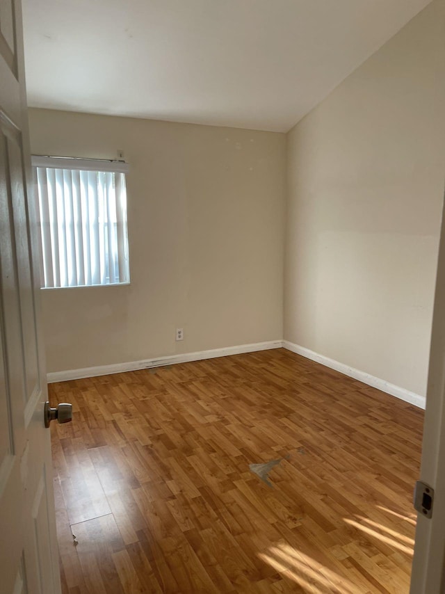 spare room featuring wood-type flooring