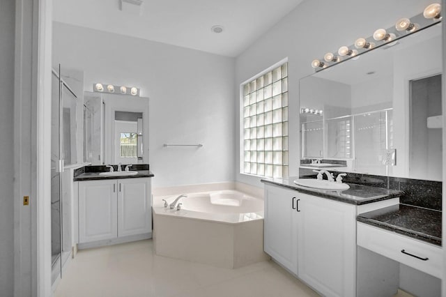 bathroom featuring vanity, tile patterned flooring, and plus walk in shower