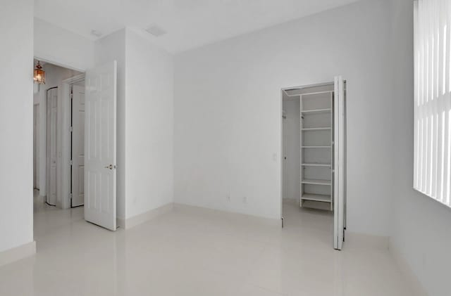 unfurnished bedroom with a spacious closet and a closet