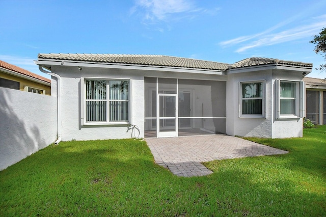 rear view of property featuring a patio, a sunroom, and a yard