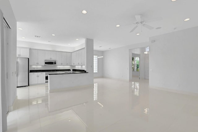 kitchen with sink, white cabinetry, appliances with stainless steel finishes, kitchen peninsula, and ceiling fan