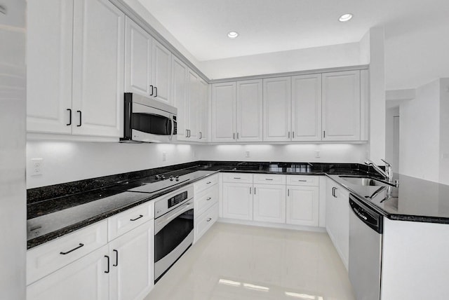 kitchen with dark stone countertops, white cabinets, and appliances with stainless steel finishes