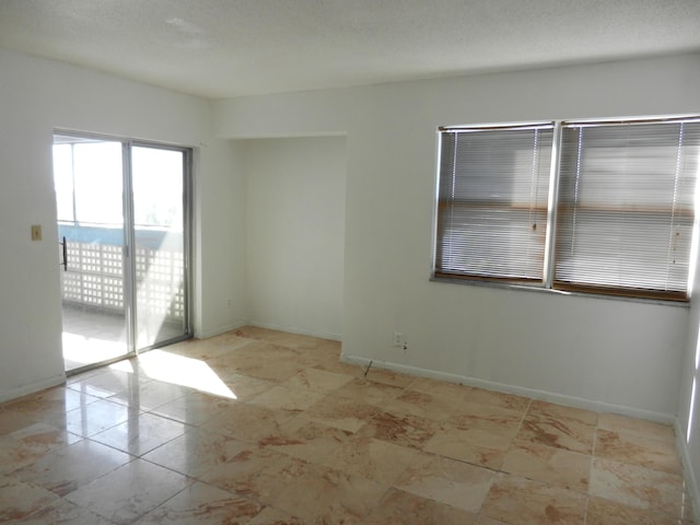 unfurnished room with a textured ceiling