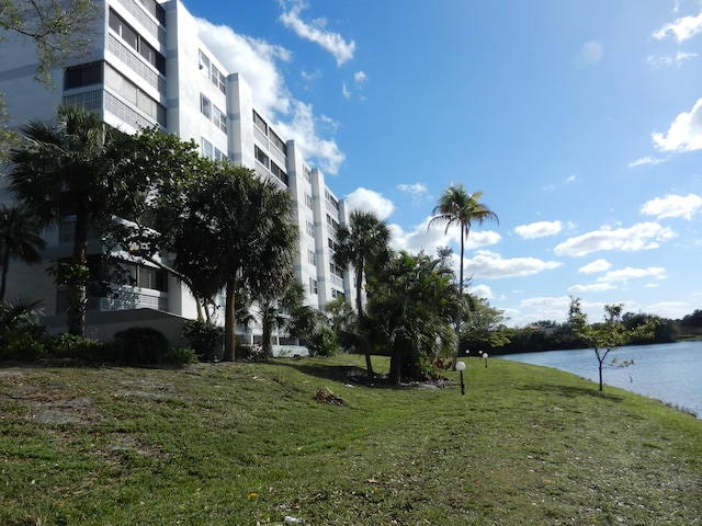 view of home's community with a water view and a yard