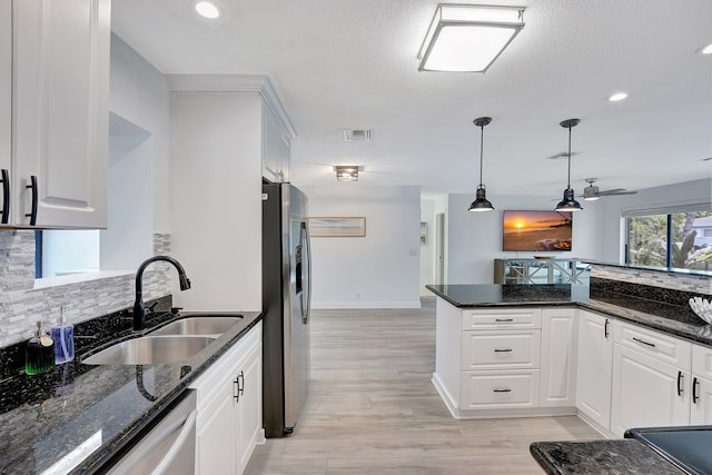 kitchen featuring dark stone countertops, sink, white cabinets, and appliances with stainless steel finishes