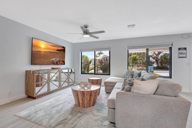 living room with ceiling fan, light hardwood / wood-style flooring, and a wealth of natural light