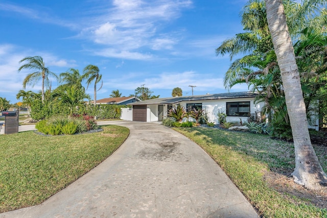 ranch-style home featuring a garage and a front yard