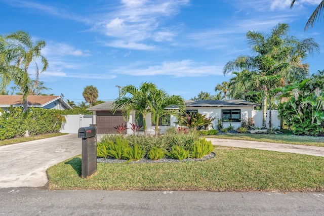 view of front of house with a garage and a front lawn