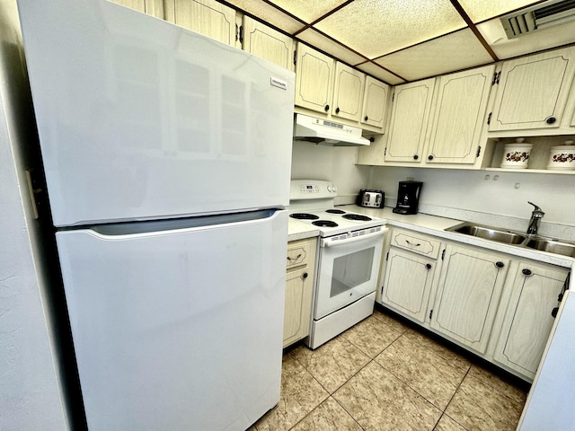 kitchen featuring a drop ceiling, sink, white appliances, and light tile patterned flooring