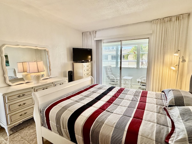 tiled bedroom with access to exterior and a textured ceiling