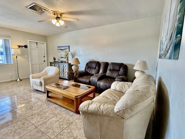 tiled living room with ceiling fan and a textured ceiling