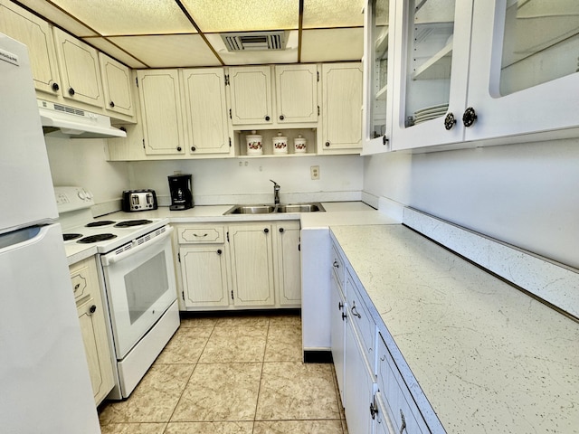 kitchen featuring white appliances, sink, and light tile patterned floors