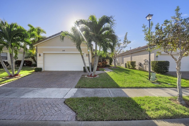 ranch-style home featuring a garage and a front lawn