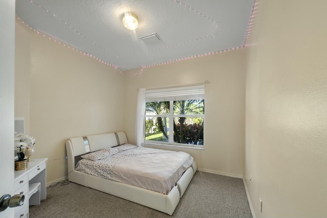 bedroom featuring light colored carpet and a textured ceiling