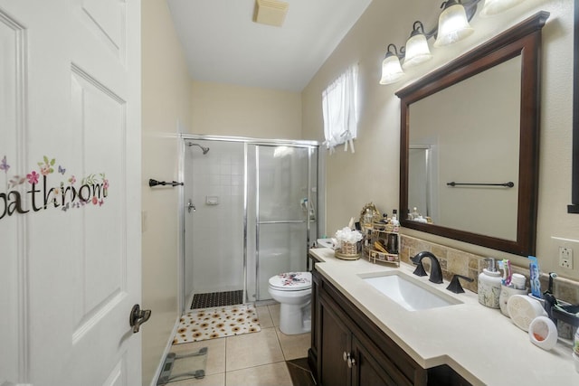 bathroom with vanity, a shower with door, tile patterned floors, and toilet