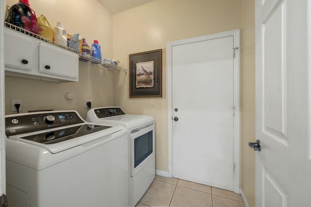 washroom with cabinets, separate washer and dryer, and light tile patterned floors