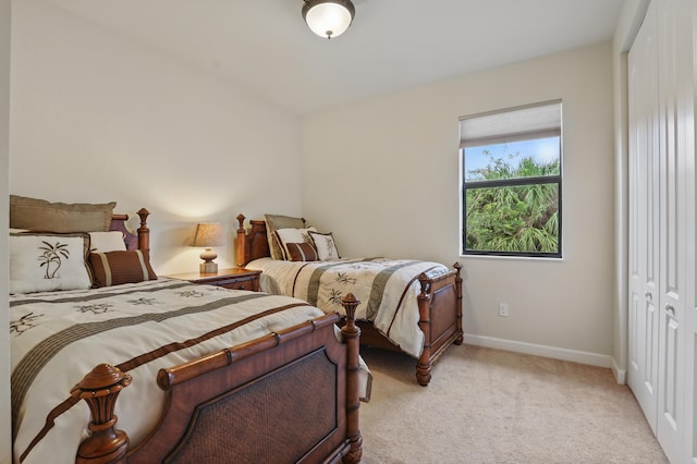 bedroom featuring light carpet and a closet