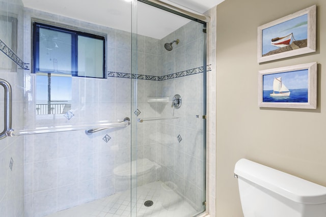 bathroom with a shower with door and toilet