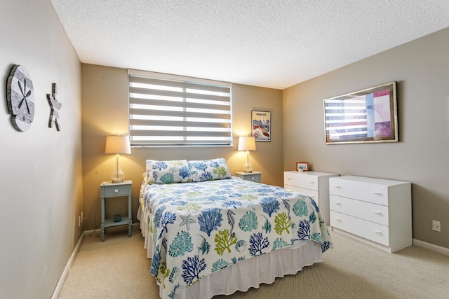 bedroom featuring light colored carpet and a textured ceiling